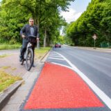 Patrick Berner (ADFC) steht in Herten mit seinem Fahrrad an der Straße Über den Knöchel. Der Radweg führt an dieser Stelle vom Gehweg auf die Straße.