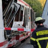 Ein Feuerwehrmann steht vor der völlig zerstörten Straßenbahn in Dortmund.