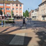 Ein Radfahrer schiebt sein Rad über einen Zebrastreifen.