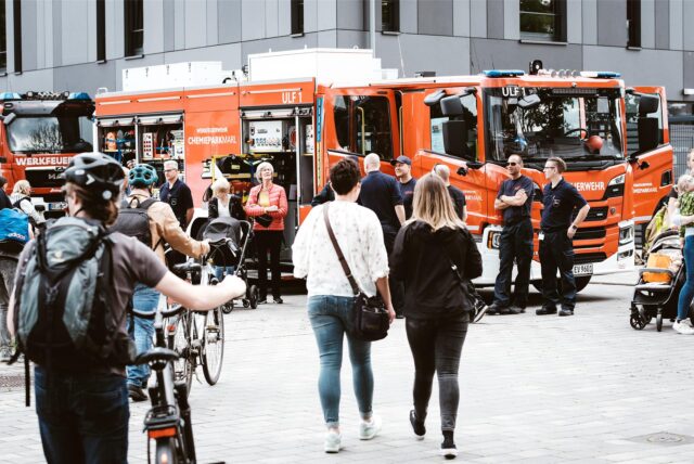 Passanten laufen Richtung eines Feuerwehrwagens.