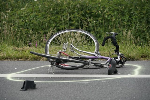 Auf der Straße liegt ein verbeultes Rennrad.