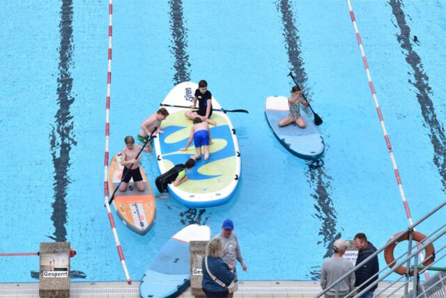 Kinder auf Stand-up Paddle im Freibad Sythen