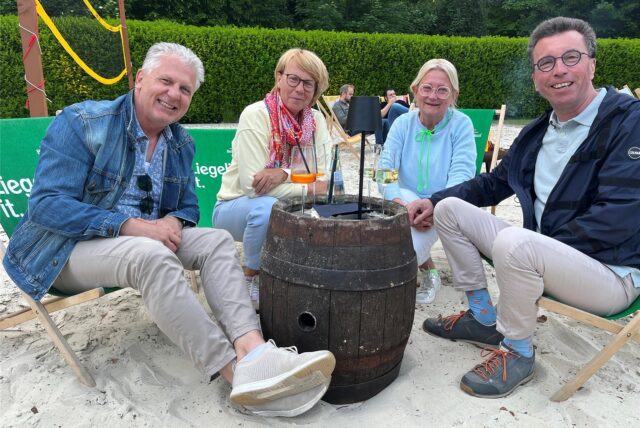 Vier Menschen sitzen in Liegestühlen.