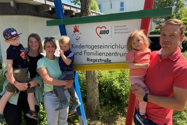 Stehen vor einem Schild der Kita Rappelkiste: (v.l.) Adriane Godiszewski mit Sohn Paul sowie Martina Körner mit Sohn Lio und Robert Körner mit Tochter Ella ein dauerhaftes Ende der Notbetreuung und mehr Verlässlichkeit.