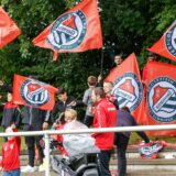 Fans von Rot Weiß Germania mit Vereinsfahnen auf den Tribünenstufen des Sportplatzes Im Odemsloh.