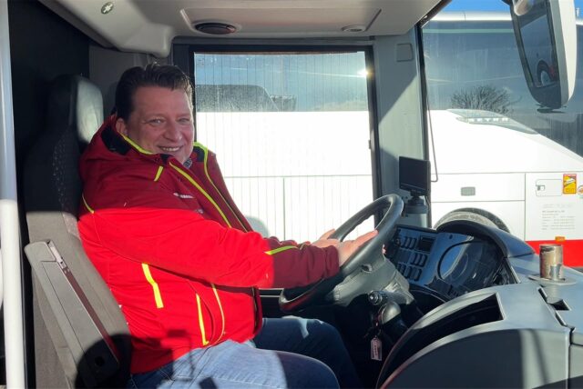 Daniel Minarzik sitzt am Lenkrad eines Busses.