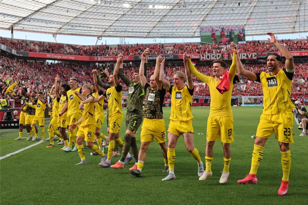 Die Mannschaft von Borussia Dortmund bejubelt ihren Sieg im Bundesliga-Spiel gegen Bayer Leverkusen vor dem Gästeblock der BayArena. Die Mannschaft von Borussia Dortmund bejubelt ihren Sieg im Bundesliga-Spiel gegen Bayer Leverkusen vor dem Gästeblock der BayArena.