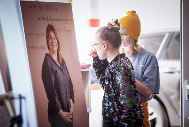 Zwei Mädchen schauen sich ein Plakat an