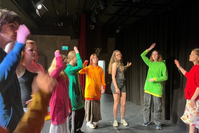 Das Junge Ensemble des Lea-Drüppel-Theaters steht auf der Bühne und probt einen Song.