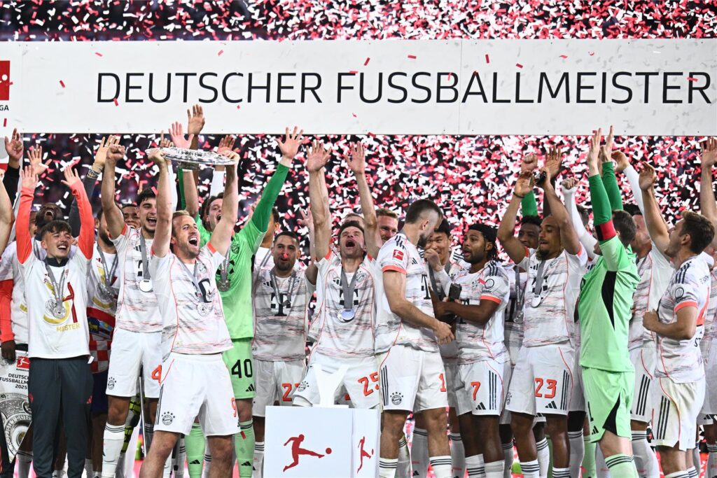 Die Spieler des FC Bayern München jubeln mit der Meisterschale, die Harry Kane in den Händen hält.