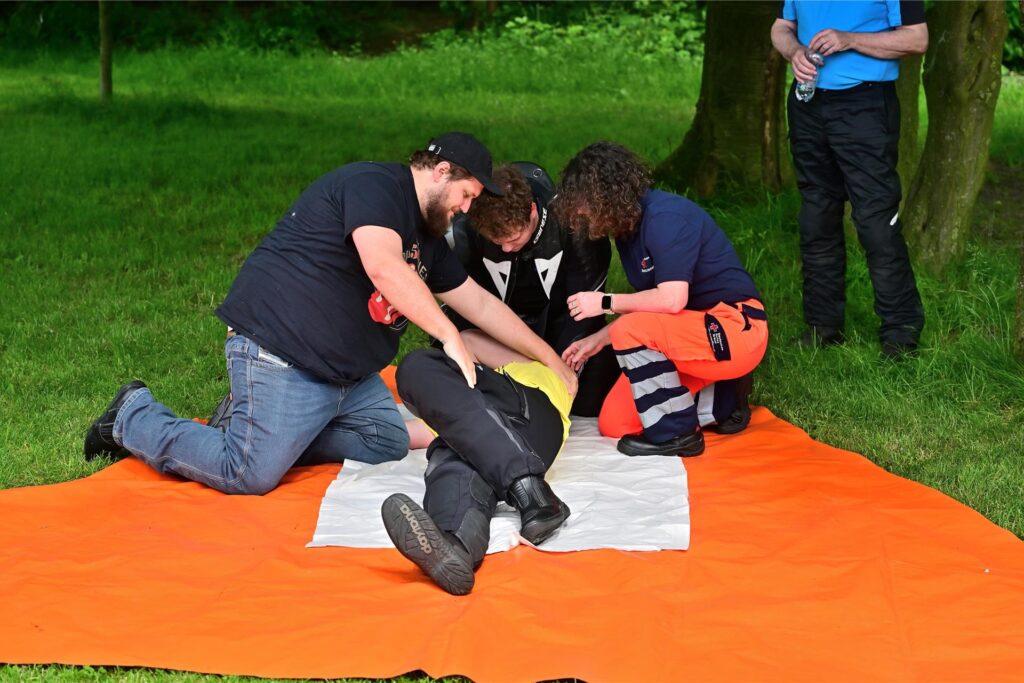 Vier Personen simulieren einen Erste-Hilfe-Einsatz.