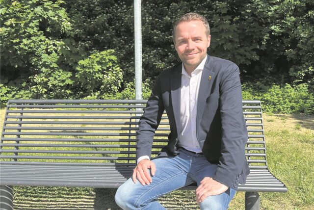 Bürgermeister Marcel Mittelbach sitzt auf einer Parkbank.