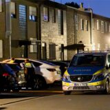 Ein Polizeiwagen steht vor einer Häuserreihe mit geparkten Fahrzeugen in Gladbeck.
