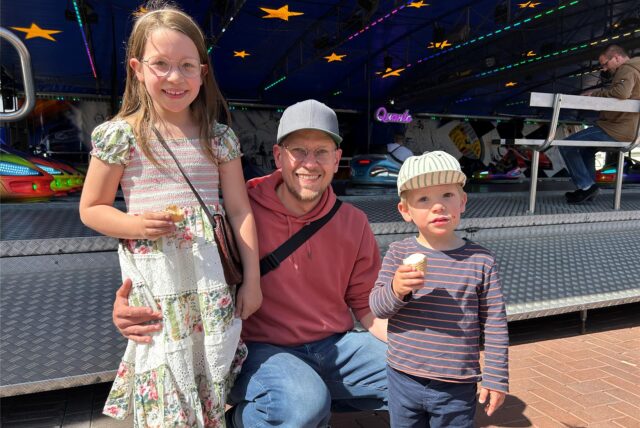 Ein Vater und zwei Kinder mit Eis vor dem Autoscooter bei der Waltroper Frühjahrskirmes.