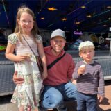 Ein Vater und zwei Kinder mit Eis vor dem Autoscooter bei der Waltroper Frühjahrskirmes.