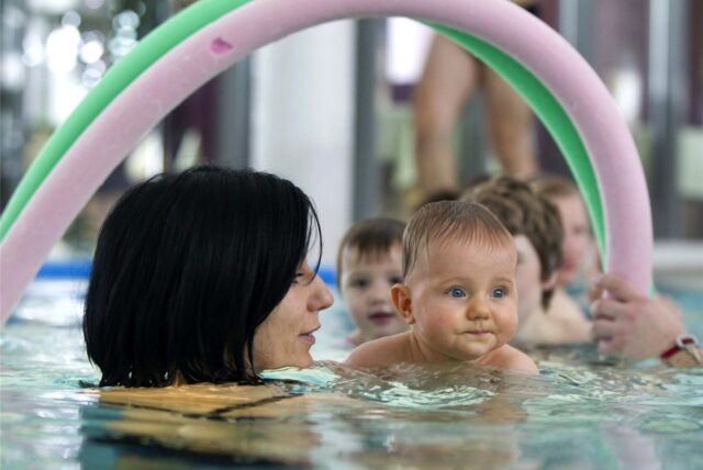 Ein Baby mit seiner Mutter bei einem Schwimmkurs.