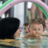 Ein Baby mit seiner Mutter bei einem Schwimmkurs.