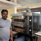 Der Betreiber der Pizzeria Bambino, Kesavan Sivasubremaniam, vor seinem neuen Pizzaofen.