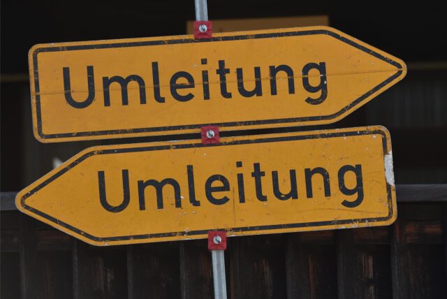 Zwei Umleitungsschilder zeigen in unterschiedliche Richtungen.