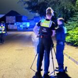 Zwei Beamte des Verkehrsunfall-Teams der Polizei stehen nach dem tödlichen Unfall in Marl, bei dem ein Radfahrer starb, an einer Kamera auf dem Dümmerweg.