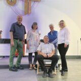 Vier Menschen hinter einem Mann, der im Liegestuhl sitzt.