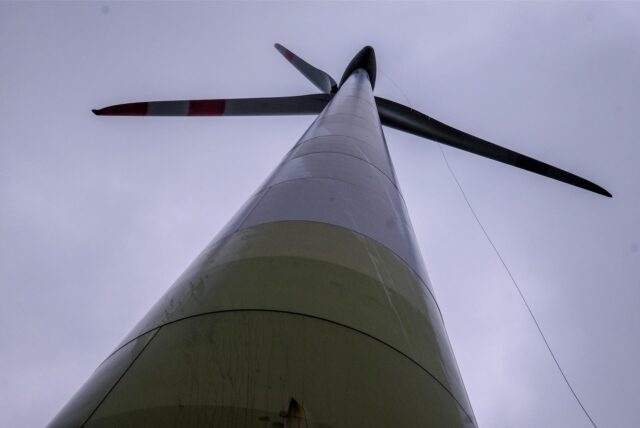 Ein Windrad, von unten zum Rotor hinauf fotografiert.
