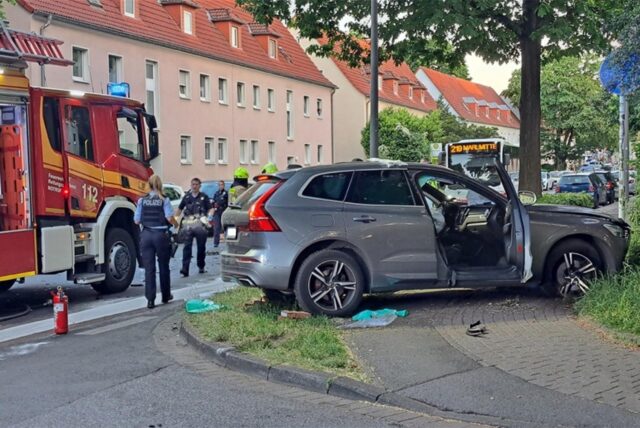Ein SUV steht neben der Straße, Feuerwehr im Hintergrund.