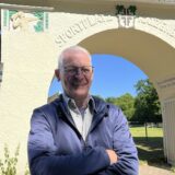 Haupteingangstor der Sportanlage, davor steht Norbert van Gemmern, seit 2024 der 1. Vorsitzende des Vereins