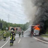 Feuerwehrkräfte löschen auf der B236 in Dortmund einen brennenden Reisebus.