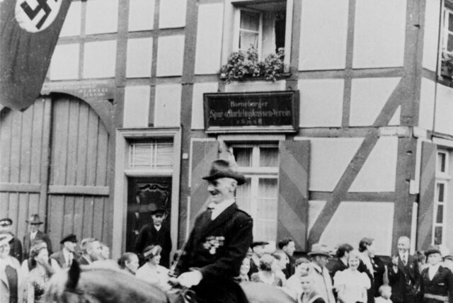 Historisches Foto aus Horneburg: Ein Mann reitet an Menschen vorbei.