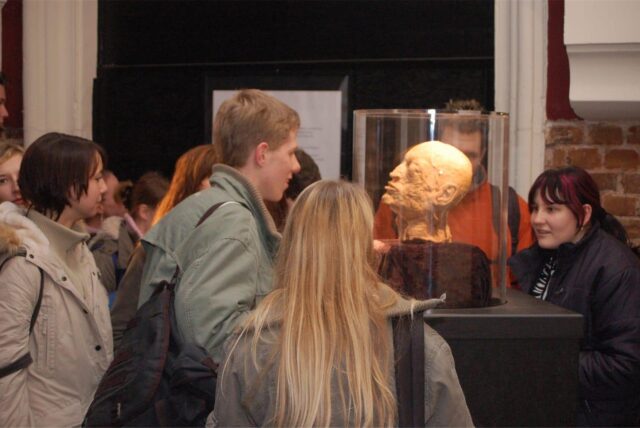 Menschen betrachten einen plastinierten Schädel der Ausstellung „Der menschliche Körper“