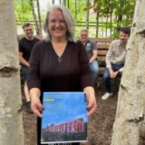 Mitorganisatorin Tanja Kramer hält eine Seite des ExtraSchicht-Programms auf der Neuen Zeche Westerholt in Händen, dahinter sitzen Christian Stoll (l.) und Christopher Fischer vom Circus Schnick-Schnack aus Herne sowie Bernd Lohse, Geschäftsführer der Zechen-Entwicklungsgesellschaft.