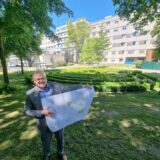 Ein Mann steht im Garten des St. Vincenz und präsentiert einen Bauplan.