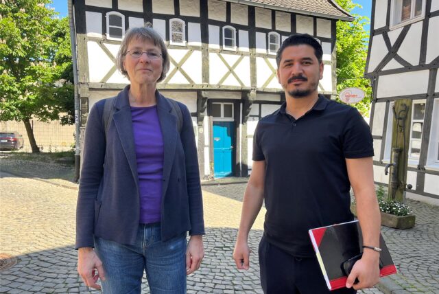 Zwei Menschen stehen vor dem Tempel-Fachwerkhaus in Waltrop.