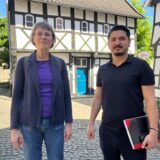 Zwei Menschen stehen vor dem Tempel-Fachwerkhaus in Waltrop.
