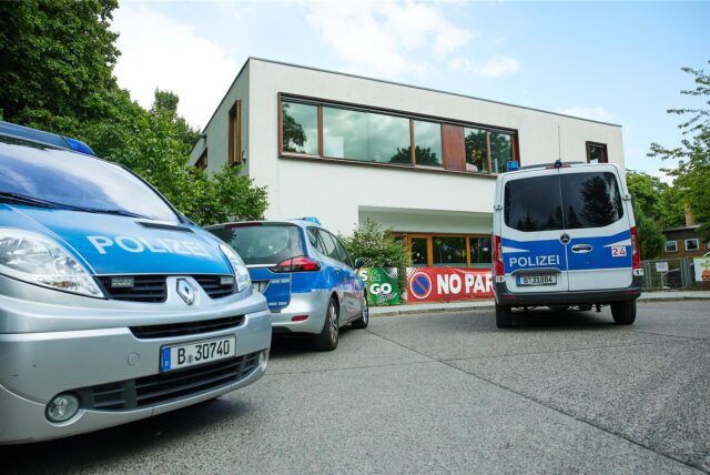 Fahrzeuge der Polizei stehen vor einer Schule im Berliner Bezirk Spandau. Ein schwer verletzter Zwölfjähriger sei dort gefunden worden und zur Operation und weiteren stationären Behandlung in ein Krankenhaus gebracht worden.