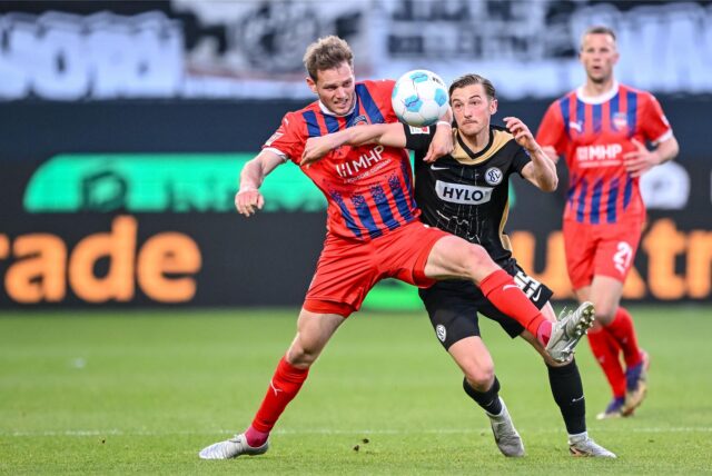Tim Siersleben (1. FC Heidenheim) und Lukas Petkov (SV Elversberg) kämpfen im Hinspiel der Relegation zur Bundesliga 2025 um den Ball.