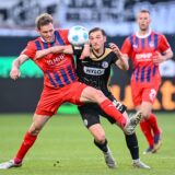 Tim Siersleben (1. FC Heidenheim) und Lukas Petkov (SV Elversberg) kämpfen im Hinspiel der Relegation zur Bundesliga 2025 um den Ball.
