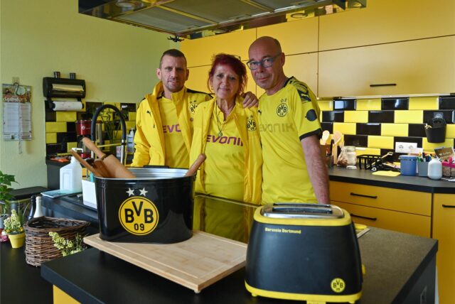 Kristina Walter mit ihrem Sohn Silvio (l) und ihr Mann Andreas stehen in ihrer schwarz-gelben Küche. Kristina Walter ist glühender Fan des Fußballvereins Borussia Dortmund. Die Vereinsfarben Schwarz-Gelb begleiten sie optisch schon lange.