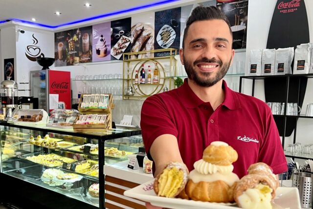 Abdullah Alessa vom Team des Cafés präsentiert süße Leckereien.
