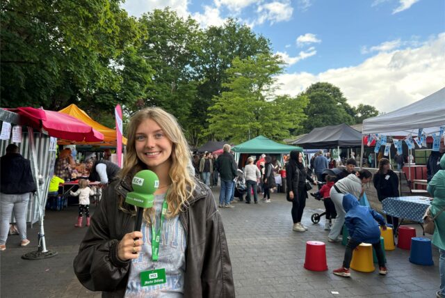 Vivien Caspers steht mit einem Mikrofon auf dem Markt der Möglichkeiten.