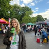Vivien Caspers steht mit einem Mikrofon auf dem Markt der Möglichkeiten.