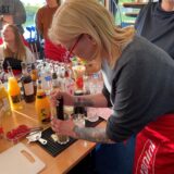 Eine Frau drückt mit einem Stößel eine Limette in einem Glas aus.