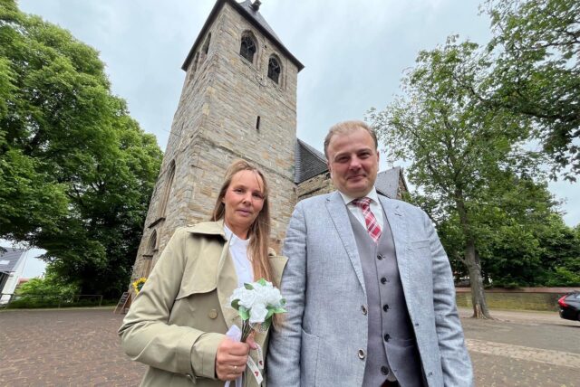 Melanie und Christian Traphan stehen vor der evangelischen Kirche in Brackel.
