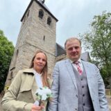 Melanie und Christian Traphan stehen vor der evangelischen Kirche in Brackel.