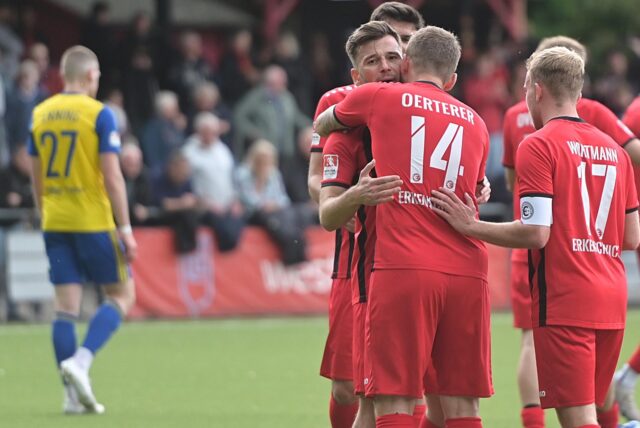 Erleichterung bei der Spvgg. Erkenschwick: Stefan „Ö“ Oerterer nimmt den Torschützen zum 1:0, Arda Nebi, in die Arme, Kapitän Finn Wortmann beteiligt sich am Schmusen.