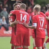 Erleichterung bei der Spvgg. Erkenschwick: Stefan „Ö“ Oerterer nimmt den Torschützen zum 1:0, Arda Nebi, in die Arme, Kapitän Finn Wortmann beteiligt sich am Schmusen.