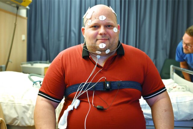 Dustin Wegener sitzt verkabelt auf einem Krankenbett.