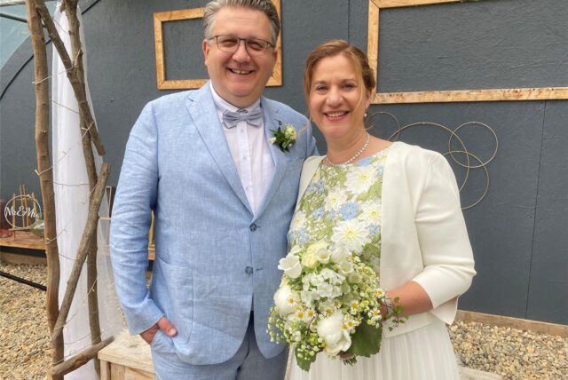 Ein Hochzeitspaar schaut in die Kamera.