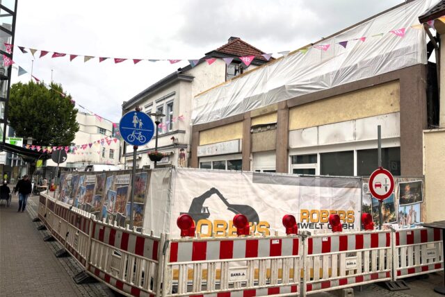 Die Abrissarbeiten der Immobilie Holzmarkt 8 in der Innenstadt von Recklinghausen haben begonnen. Absperrungen stehen vor dem Gebäude.